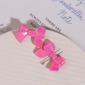 Macro view of pink pearlescent 3D bow jewelry pendants with silver metal rings - 1 Piece / Rose Red
