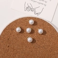 Detail of five round faux pearl charms with golden metal loops for DIY jewelry making - 8mm
