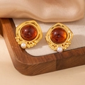 Detail of vintage gold earrings with amber stone and white pearl on satin fabric - Geometric Rhombus Amber Stone Artificial Pearl Stud 1961
