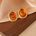 Detailed view of vintage gold stud earrings with amber stones on satin fabric - Geometric Oval Amber Stone Stud 1967