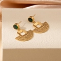 Close-up of vintage gold fan-shaped stud earrings with green gemstones on silk - Green Zircon Square Fan Stud Earrings (1988)