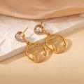 Close-up of gold stainless steel sun and star earrings on elegant silk background - White Zirconia Sun Star Style (2003)