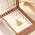 Dettaglio di una collana con ciondolo a teiera d'oro in una scatola per gioielli - Stile Pendente Bollitore (0871)