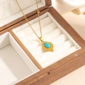 Detail of bohemian gold teardrop pendant with turquoise stone inlay in wooden box - Water Drop Turquoise Necklace