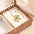 Macro view of gold horse pendant with blue turquoise stone on white velvet lining - Small Pony Turquoise Necklace (0858)