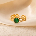 Detailed close-up of a gold hollow heart ring with a green gemstone on satin - Openwork Heart Green Cat's Eye Adjustable Style (TYR1016)