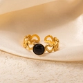 Detail of gold heart-shaped cut-out ring with a round black stone on silk fabric - Openwork Heart Black Stone Adjustable Style (TYR1022)