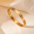 Detalle de brazalete chapado en oro 18k con grabado de diamantes sobre seda blanca - Estilo Textura Cruzada