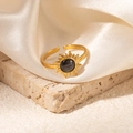 Macro shot of gold sunflower ring featuring a dark grey gemstone on silk background - Sunburst Dark Grey Stone Adjustable Style (TYR1036)