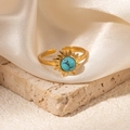 Detailed shot of golden sunflower ring with green turquoise stone on white silk - Sunburst Turquoise Adjustable Style (TYR1034)