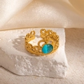 Close-up of gold crown ring with cat-eye stone on white stone and satin fabric - Crown Design Blue Stone Adjustable Style (TYR1343)