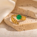 Detailed shot of vintage gold leaf ring with a round green gemstone on stone background - Wheat Texture Green Stone Adjustable Style (TYR1136)
