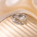Detailed view of silver feather open ring with fine texture on soft fabric background - Feather Texture Style (8) / Steel