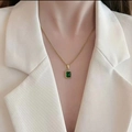 Elegant gold titanium necklace with a square green gemstone worn by a model in a beige suit - Square Green Gem Style (TY-square)