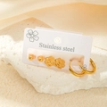 Lot de trois paires de boucles d'oreilles en acier inoxydable doré sur carte de support - Ensemble Créoles Pétale Évidé (TYE0432)