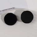 Close-up of black resin and flocked velvet circular DIY accessories on ceramic tray - Black