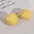 Macro detail of glossy light yellow heart resin earrings on a minimalist background - Yellow Heart