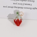 Dettaglio macro del ciondolo a fragola fatto a mano con accento di perle d'acqua dolce - Fragola Perla Rossa
