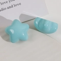 Macro shot of two glossy light blue resin star and heart-shaped charms for hair DIY accessories - Green Five-point Star