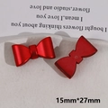 Macro detail of red bow resin charm with 15mm by 27mm dimensions on ceramic plate - Bow