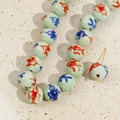 Macro detail of 12mm ceramic beads with hand-painted red and blue fish patterns - 11# Green Bird Bead (Fish Pattern) / 12mm (1 Piece)
