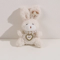 Dettaglio di un coniglio di peluche bianco con collana di perle e ciondolo a cuore lucido - Coniglio Bianco