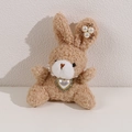 Detail of light brown curly plush bunny with pearl heart necklace and rhinestone ear decor - Coffee Rabbit