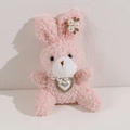 Dettaglio di coniglio di peluche rosa con collana di perle e ciondolo a cuore - Coniglio Rosa
