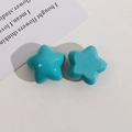 Gros plan de charms étoiles en résine bleu brillant pour bijoux et accessoires DIY - Bleu Lac