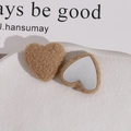 Macro view of plush heart-shaped khaki faux fur accessories with flat metal backing - Light Coffee