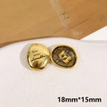 Dettaglio macro di bottoni ovali dorati 18mm con incisione corsiva e trama posteriore - Stile Ovale Oro