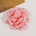 Detaillierte Nahaufnahme einer rosa geschichteten Stoff-Kamelienblüte mit Seidentextur - Rosa