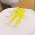 Detail von handgefertigten gelben Glasperlen-Quasten mit weißen Maiglöckchen-Anhängern - Gelb