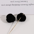 Gros plan d'accessoire de bijoux rose floquée noire avec un détail élégant d'aiguille dorée - Noir