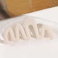 Detail einer welligen Plüsch-Haarklammer in Creme-Beige mit einer weichen Beflockung - Weiß