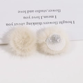 Detailweergave van 3 cm crème pluche pompons met bovenkant van bont en bevestigingsbasis - Broken Wit