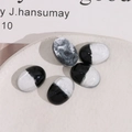 Macro detail of oval resin patches with black and silver marble texture for DIY accessories - Black + White