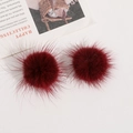 Nahaufnahme von flauschigen weinroten Kunstpelz-Pompons für DIY-Schmuck und Accessoires - Burgunderrot