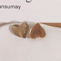 Macro detail of heart-shaped resin charms with brown glossy finish and textured back - Brown