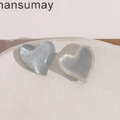 Close-up of marble blue and translucent white resin heart charms for DIY jewelry making - Gray