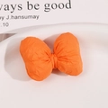 Detailansicht einer leuchtend orangefarbenen Stoffschleife mit natürlicher Textur - Orange