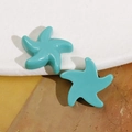 Primo piano di orecchini a lobo a forma di stella marina color verde acqua lucido - Blu