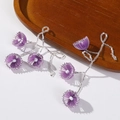 Detailed macro view of purple petal beads and intricate woven floral tassels on earrings - Purple
