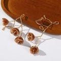 Detailed close-up of handmade beaded long tassel ornaments with brown floral petal accents - Brown