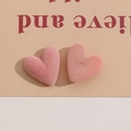 Dettaglio ravvicinato di ciondoli a cuore floccati rosa che mostrano la texture morbida - Rosa