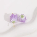 Detailed close-up of purple acrylic tulip beads with glitter on a white ceramic tray - 1 Piece / Light Purple