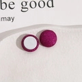 Vue macro de boucles d'oreilles magnétiques pailletées rose pourpre à texture givrée - Fuchsia