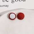 Vue macro de boucles d'oreilles magnétiques rouges pailletées de 15mm de diamètre - Rouge Foncé