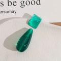 Detail of translucent green resin earrings with hammered texture on a ceramic tray - Square and Teardrop Perforated Style Combination