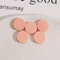 Close-up of 13mm round peach resin cabochons for DIY jewelry on a white ceramic tray - Light Pink